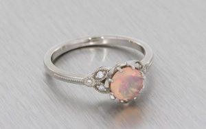 A Delicate And Vintage Inspired Palladium Engagement Ring Set With A Faceted Opal
