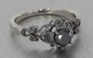 Gothic style ring set with black diamonds with scroll work and skull details