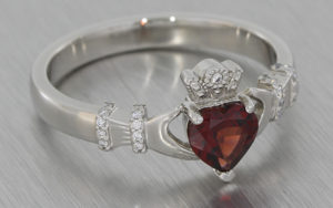 Platinum claddagh ring set with a garnet and diamonds