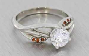 Organic platinum engagement ring set with a Brilliant cut Diamond and red garnets