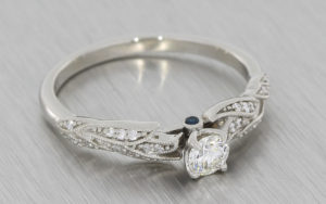 Platinum nature inspired engagement ring featuring a brilliant cut diamond with tourmaline peak stones