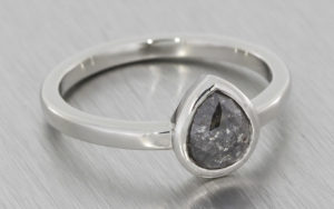 Platinum ring with a bezel set salt and pepper diamond