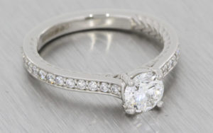 Platinum round brilliant diamond ring with intricate rope work and diamond set shoulders