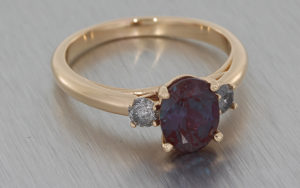 Trilogy ring crafted in 18k rose gold set with an oval Alexandrite with two smaller round salt & pepper diamonds on either side
