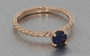 Rose gold twisted band with a round sapphire