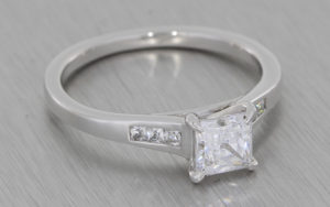 Silver proposal ring set with a square cubic zirconia with smaller squares in the shoulders